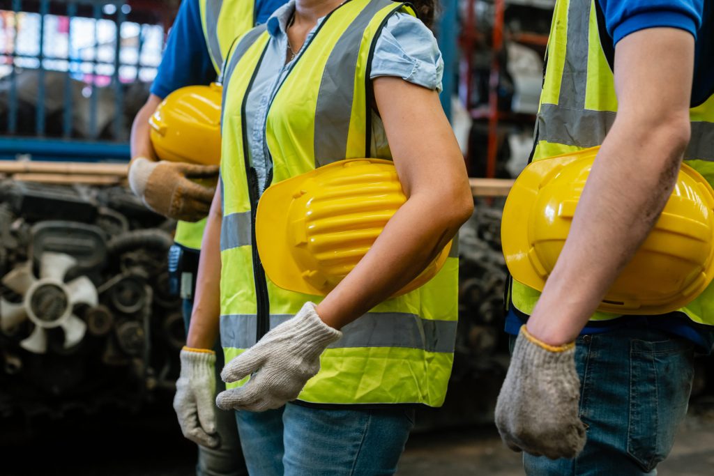 Close up of hardhats of health and safety professionals in a warehouse or factory.