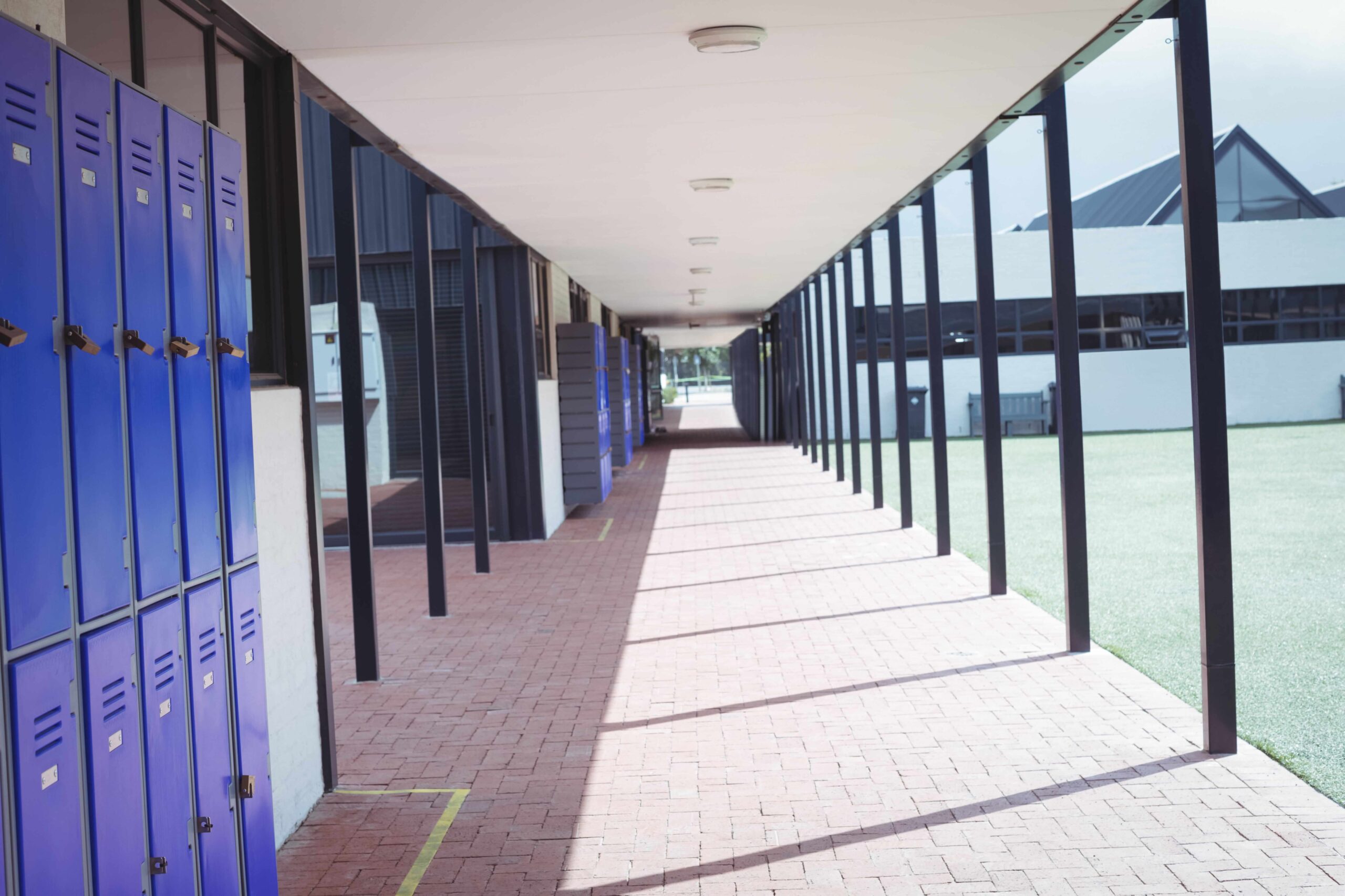 An empty hallway in a school setting, with lockers on the left.