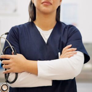 A close-up of a nurse with hands and arms crossed with a stethoscope in one hand, in a medical space